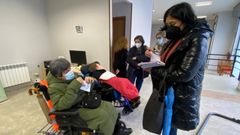 Elena Cando junto a usuarios de Aspnais estudiando la creaci�n de atenci�n postemper�