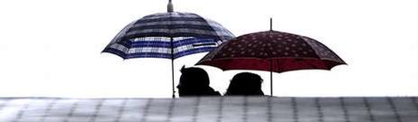 Dos ciudadanos se cruzan por la calle Garc�a Barb�n con sus respectivos paraguas, uno de los objetos m�s vendidos y usados este invierno en Vigo.