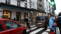 Un viandante cruza con el semforo en verde para los vehculos en el paso de cebra que une plaza de Galicia con Fonte de Santo Antonio