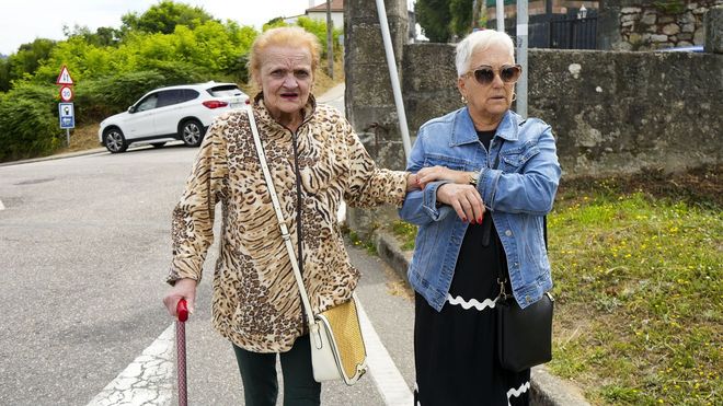 Caminando cerca de su casa acompa�ada por una voluntaria que la ayuda