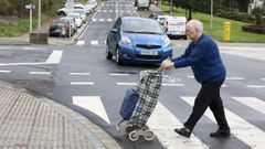 Una mujer cruza correctamente por un paso de peatones en el barrio compostelano de Fonti�as