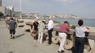 Cruceristas en el paseo mar�timo de A Coru�a viendo los trabajos de limpieza tras la noche de San Xo�n