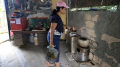 Una mujer cocina en dos hornillos de carb�n en una vivienda de La Habana.