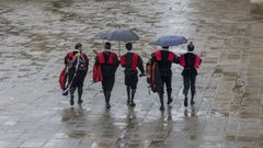 Un grupo de tunos bajo la lluvia en Santiago