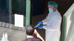 Un trabajador de la residencia de mayores de O Incio, en la puerta del entro con un traje especial