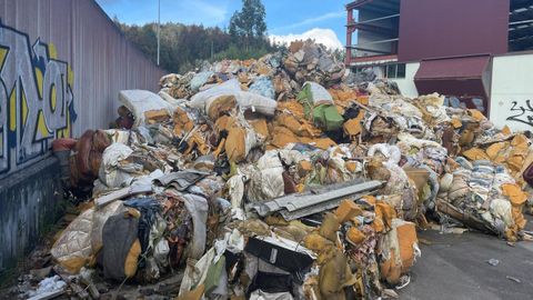 Montaas de colchones y todo tipo de residuos se acumulan en el polgono industrial de Ourol, en la antigua nave de Maprimetal