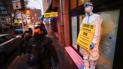 Polic�as alemanes pasan por delante de un bar reconvertido en tienda de art�culos de protecci�n contra el covid en Frankfurt