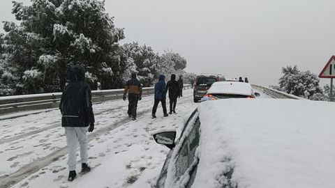 Una persona camina junto a varios veh�culos en la carretera M-519 a la altura de Galapagar.