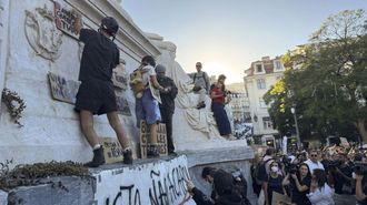 J�venes colocan pancartas mientras acampan en Lisboa.