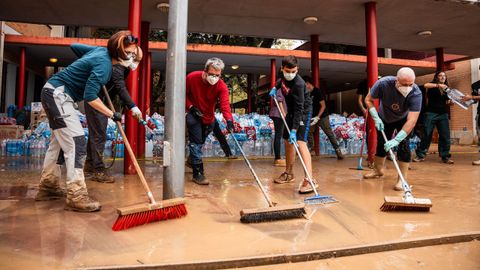 Voluntarios limpian un instituto en Picaña (Valencia) que se utiliza como almacén tras el paso de la dana