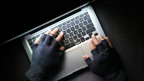 Unas manos enguantadas sobre un teclado, en una imagen de archivo.