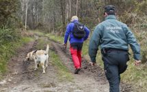 El perro, su gu�a y agentes de la Guardia Civil, en uno de los caminos por los que se concentr� el rastreo. 