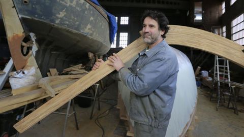 Un traballador de Astaleiros Garrido porta unha caderna dun barco no seu obradoiro.