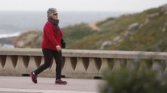 Una mujer camina por el paseo mar�timo con cielos nublados 