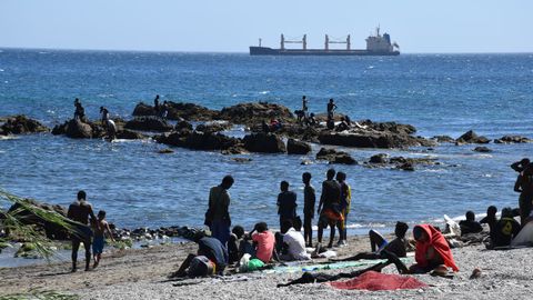 Varias personas migrantes este mi�rcoles en la playa ceut� del Trampol�n.