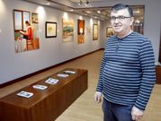 <span lang= gl >Manuel Maneiro Tato no Lustres Rivas, coa exposici�n de Xo�n Fern�ndez como pano de fondo. </span>