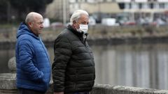 Dos varones paseando en Viveiro, uno de ellos con mascarilla