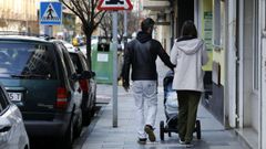 Una joven pareja pasea por las calles de Ribadeo empujando el carrito de un beb�.