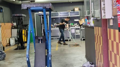 Limpieza de  uno de los bajos afectados en la calle Fernando Olmedo, en Pontevedra 