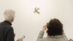 Visitantes fotograf�an la obra de Cattelan antes del robo del pl�tano, que se reemplaza cada tres d�as.