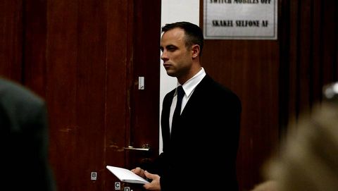 Oscar Pistorius pasa por delante de la puerta a travs de la que tiroteo a su novia tras finalizar su declaracin