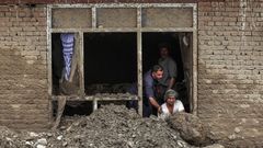 Una familia retira los escombros que la riada arrastr� hasta el interior de su casa en Charikar, ciudad de la provincia de Parwan  