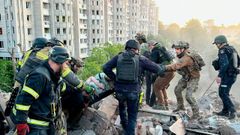Los rescatadores ayudando a heridos en uno de los edificios de Dnipro, donde un peque�o perdi� la vida, adem�s de otras once personas 