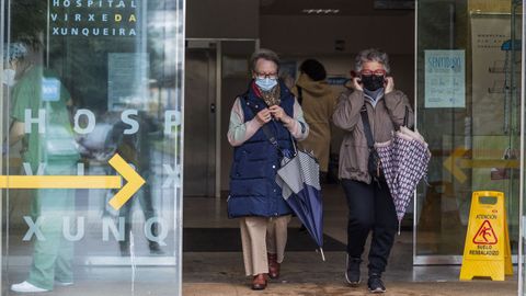 Dos mujeres con mascarilla, saliendo del Hospital de Cee.
