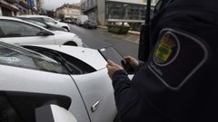 Un agente de la Polic�a Local controla la zona azul, este s�bado, en la r�a Cervantes de Carballo.