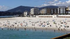 Al fondo, las casetas de la playa de A Rapadoira en los bajos del paseo mar�timo que bordea el arenal