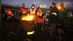 Personal de la f�brica, protegi�ndose del fr�o, en el campamento que tienen montado a la entrada 