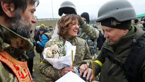 Lesia Ivashchenko y Valerii Fylymonov, miembros de las Fuerzas de Defensa Territorial de Ucrania, intercambian anillos en su boda durante el conflicto blico, en un puesto de control en Kiev, Ucrania.