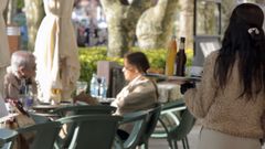 Una camarera atendiendo a clientes en la terraza de una cafeter�a