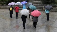 Un grupo de personas con paraguas atravesado la plaza de Espaa, en Monforte.