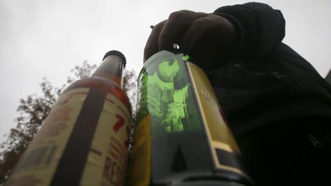 Imagen de archivo de un joven con botellas de bebidas alcohlicas.