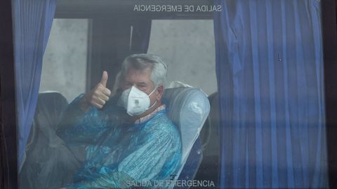 Un pasajero brit�nico del crucero MV Hondius levanta el pulgar mientras viaja en autob�s hacia el aeropuerto, en el puerto de Granadilla de Abona, en Tenerife. 