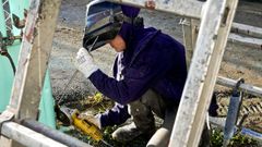 Una mujer gallega realizando labores de soldeo.