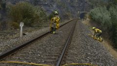 Personal antiincendios trabajando junto a las v�as del tren este lunes en Ourense