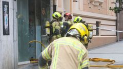 Bomberos en el incendio de un bajo okupado en la calle Dolores, la pasada semana.
