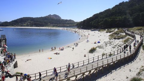 Imagen de archivo del muelle de Rodas en el que desembarcan los visitantes y el paso de madera que sobrevuela las dunas
