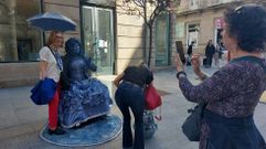 Laura Naveira, la dama victoriana de azul, junto a unas turistas en el Paseo de Ourense