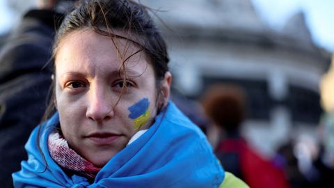 Una manifestante con una bandera ucraniana pintada en la mejilla asiste a una protesta contra la guerra en la Place de la Republique, Francia.