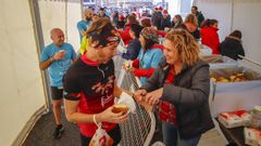 Un grupo de voluntarios se encarga de repartir en la meta el chocolate y la rosca. 
