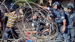 Varios manifestantes se enfrentan a los agentes de polic�a mientras tratan de traspasar la concertina que los separa para dirigirse hacia el Parlamento 