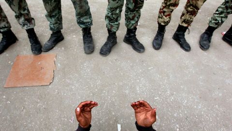 Un manifestante de la oposici�n reza frente a soldados del ej�rcito cerca de la Plaza Tahrir en El Cairo