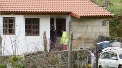 La acusada del crimen de Cortegada (con un chubasquero amarillo) entrando en su casa durante la reconstruccin del crimen