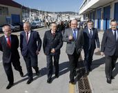 Autoridades y, al fondo, miembros del sector pesquero, en el muelle. 