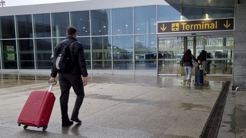 Un pasajero entrando con su maleta en el aeropuerto de Alvedro.