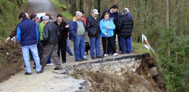 Vecinos de O Cadram�n se concentraron ayer para pedir soluciones en el punto donde la carretera se desplom�. 