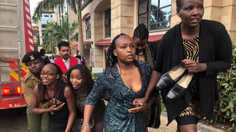 Un grupo de personas buscan refugio en la zona donde se produjo la explosi�n y los disparos, en un hotel de Nairobi, en Kenia